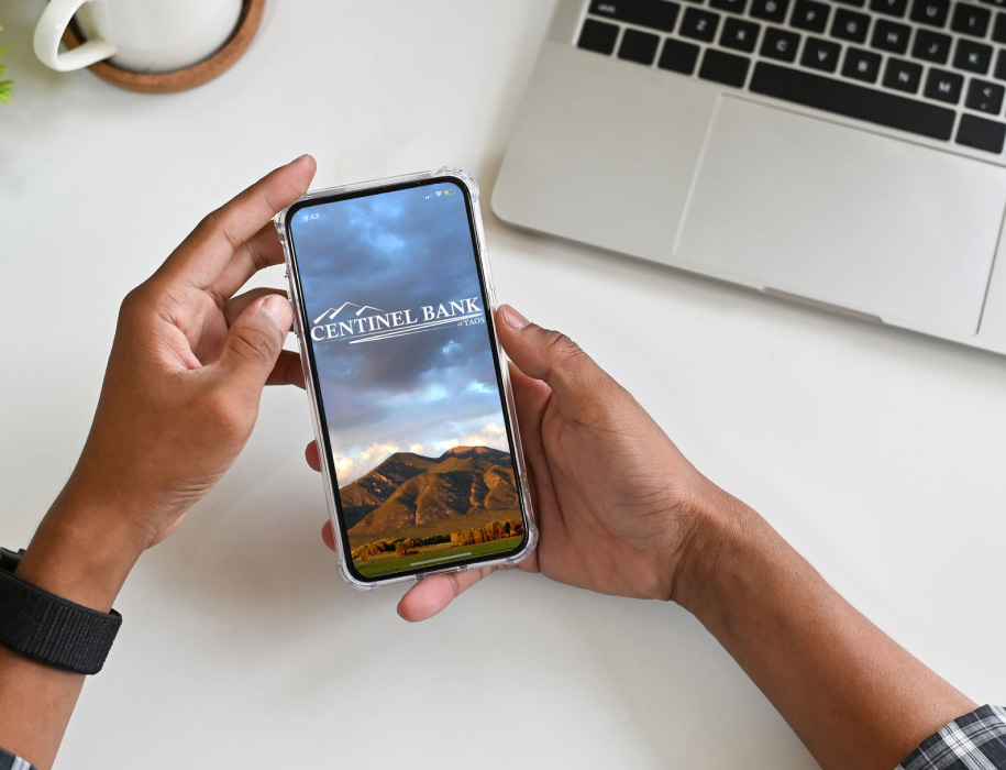 Person holding a phone with the Centinel Bank app open.