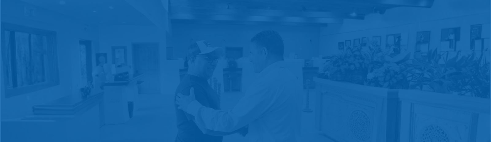 Michael Silva business customer shaking hands with Angel Reyes bank CEO in main office lobby. 